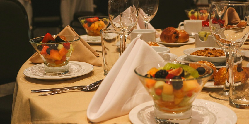A fine dining restaurant with white tableware and a centrepiece of fresh fruits near the Musical Museum.