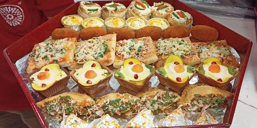 A picture of a street food vendor near Adina Mosque; an array of colourful Indian snacks