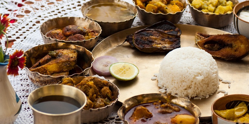 An image of a traditional Bengali meal served in Malda with local delicacies.