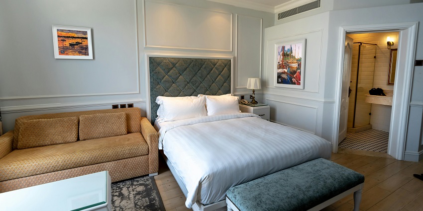 A picture of a hotel room with a cosy bed setup near Kolkata GPO Postal Museum.