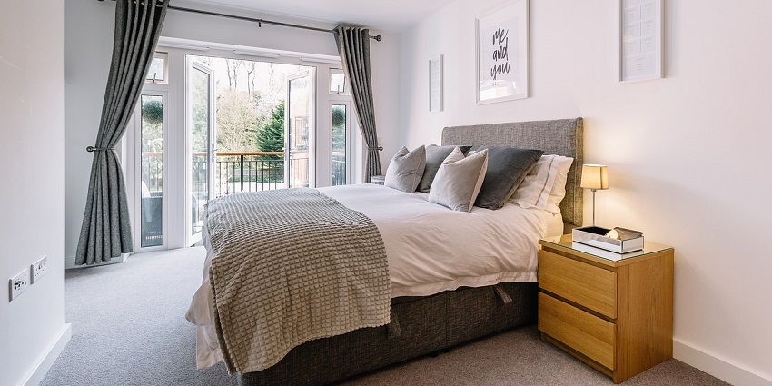 Modern bedroom with cosy bed, soft lighting, and minimalist decor for a relaxing ambiance