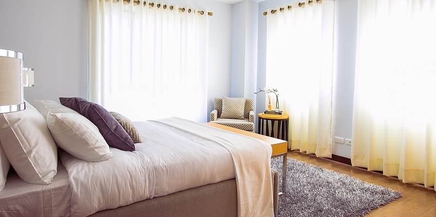 Modern bedroom with a cosy bed, soft carpet, and minimalist decor for a calming ambience