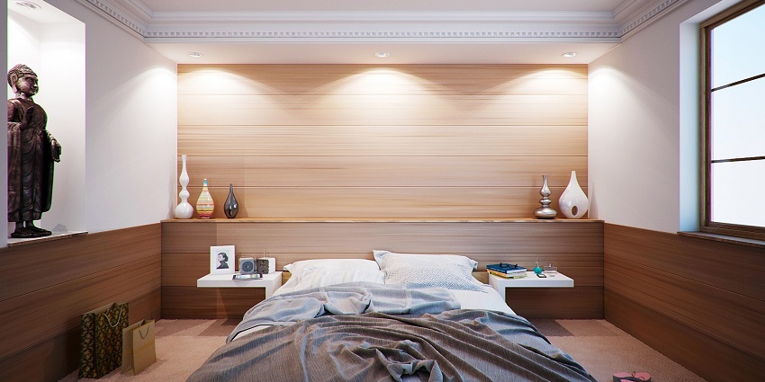 An image of a stylish apartment bedroom with a cosy bed, natural light, and warm, modern decor accents.