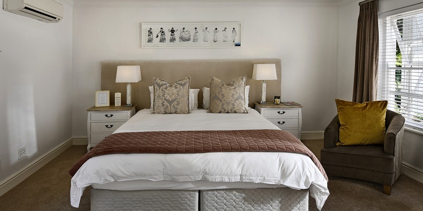 An Image of a cosy bedroom with a modern interior design, featuring a comfortable bed and soft lighting.