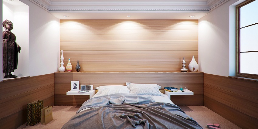 Modern bedroom with a bed, wooden furniture, and soft lighting in an apartment.