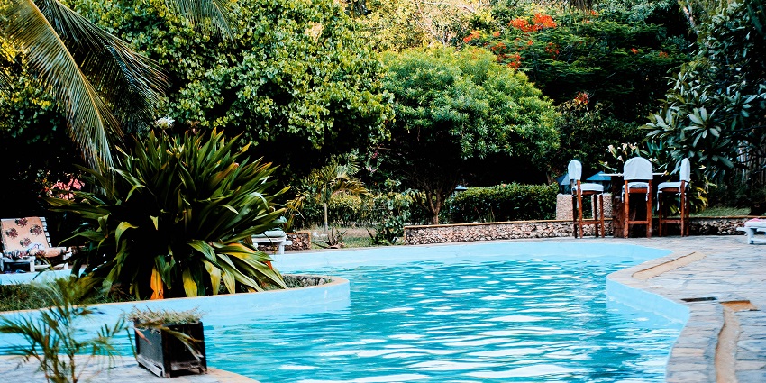 An image of the rectangular swimming pool with a tiled deck and clear blue water.