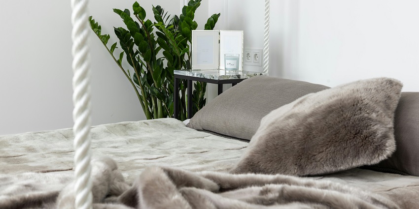 A cosy bed with pillows and blankets in a bedroom, reflecting a peaceful retreat.