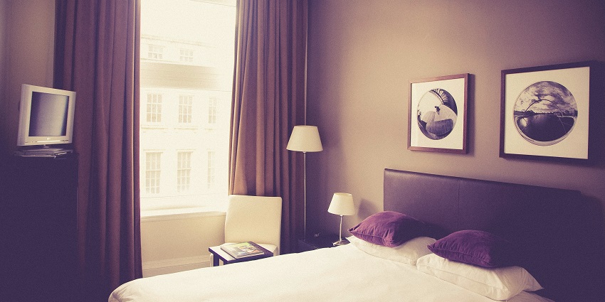 A cosy interior with a white bed and a table lamp, offering a peaceful setting for visitors.