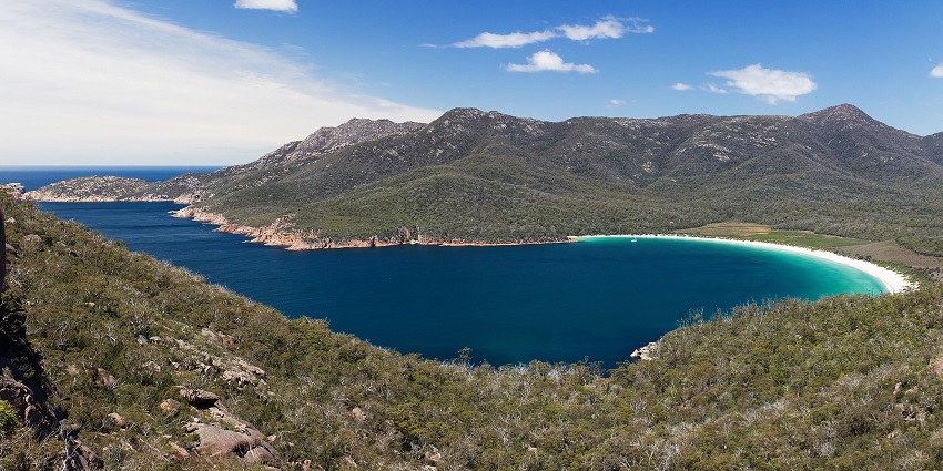 An aerial view of Wineglass Bay in Australia, a hidden gem on Tasmania's Freycinet Peninsula.