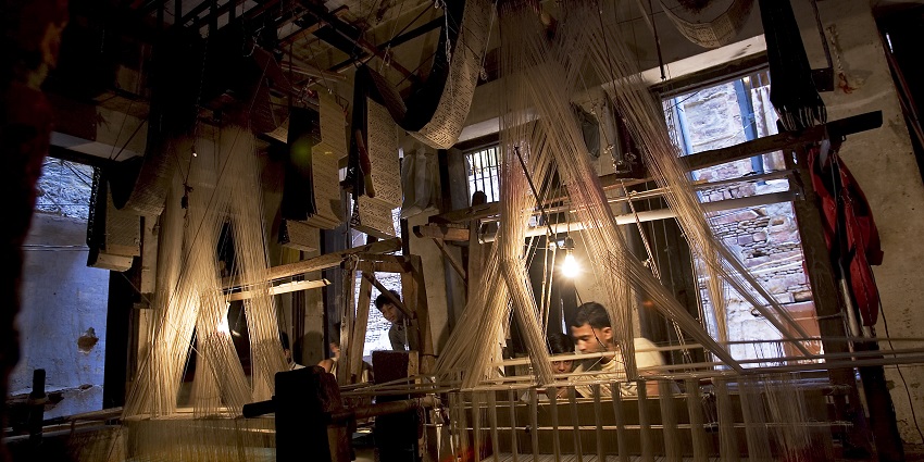 An image of weavers weaving, which is an exquisite glimpse into the very art form.