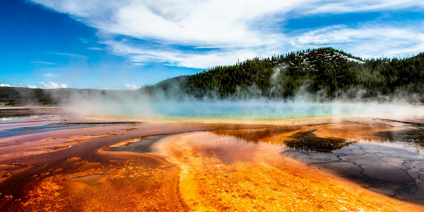 A serene view of a waterfall surrounded by nature in the Yellowstone National Park.