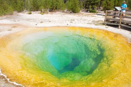 A geothermal pool in Yellowstone National Park, surrounded by rocky terrain.