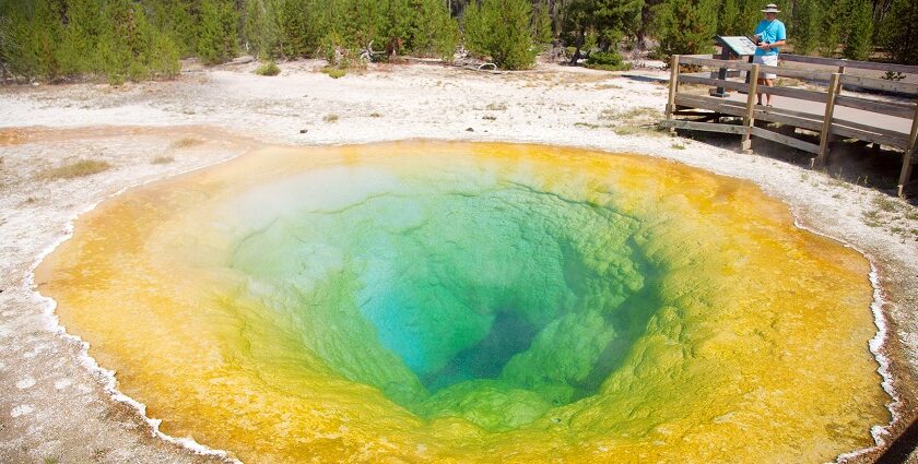 A geothermal pool in Yellowstone National Park, surrounded by rocky terrain.