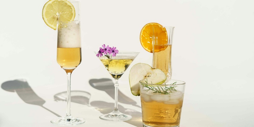 Margarita glasses with lime slices on a brown wooden surface under soft lighting