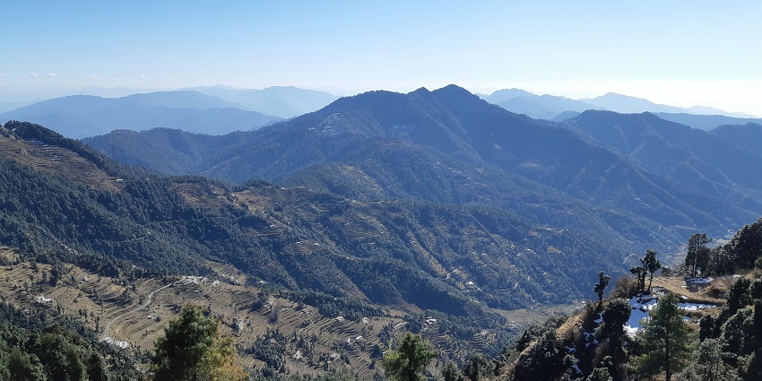 Image of Mussoorie hills covered in lush greenery under clear blue sky
