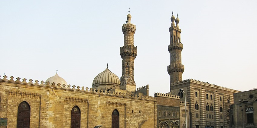 The outer architecture of Al Azhar Mosque is showcasing its minarets and the walls.