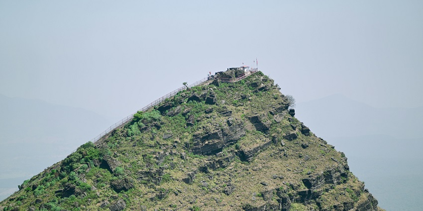 An image of a scenic view in which rolling hills and thick fog obscure the valley.