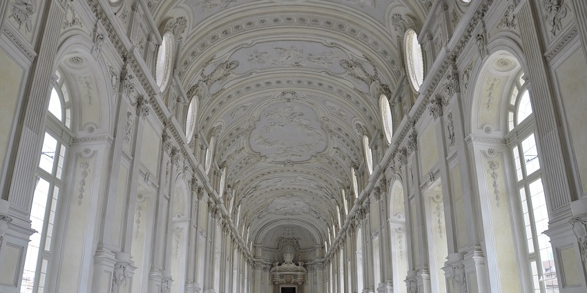 An image of the Great Gallery of the Monumental Cemetery, featuring grand arches and statues.