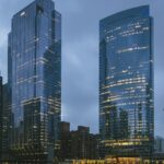 A view of the Chicago skyline at dusk with buildings and lights under a colourful sky.