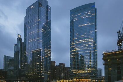 A view of the Chicago skyline at dusk with buildings and lights under a colourful sky.