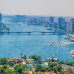 An aerial view of Egyptian city showing tall buildings, blue waters and a bridge