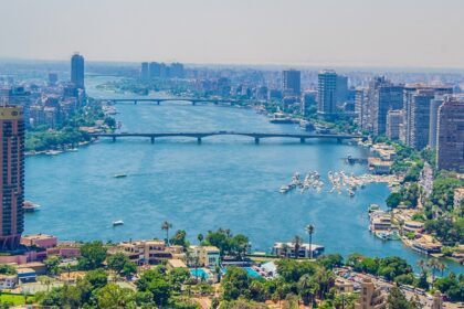 An aerial view of Egyptian city showing tall buildings, blue waters and a bridge