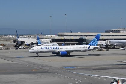 San Francisco International Airport illuminated at night with terminal lights and parked aircraft.