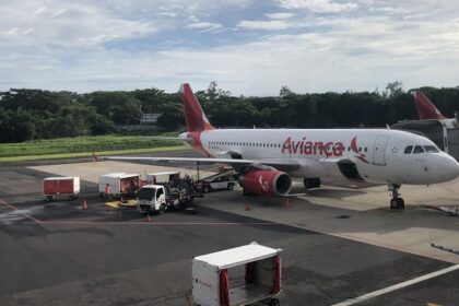 An Avianca Costa Rica plane parked at El Salvador International Airport under a clear sky.