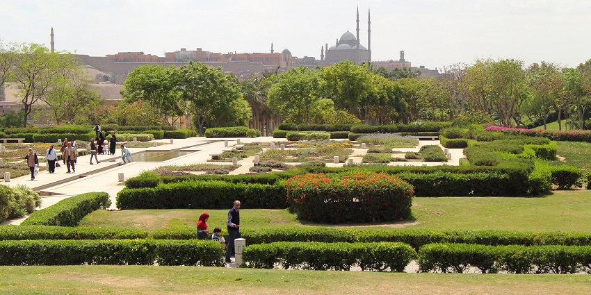 Al Azhar Park with unique garden patterns full of greenery and people walking in the park.