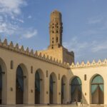 Inside view of the Al-Hakim Mosque showcasing a long hall surrounded by the buildings