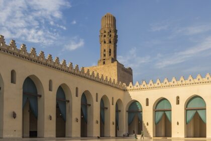 Inside view of the Al-Hakim Mosque showcasing a long hall surrounded by the buildings