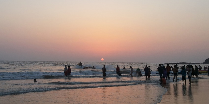 People enjoying a beautiful sunset on Alibaug Beach that is close to the Karmarkar Museum.