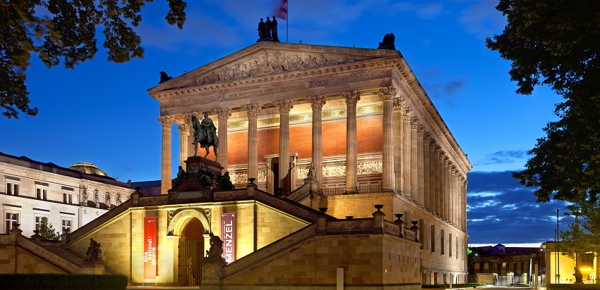 Outside the Alte Nationalgalerie and its structure and street lit with lights at night