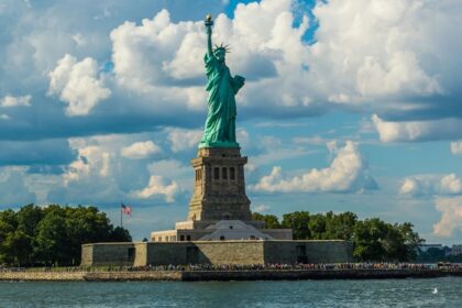 Statue of Liberty against Fluffy White Clouds - America travel guide takes you through the diverse landscapes