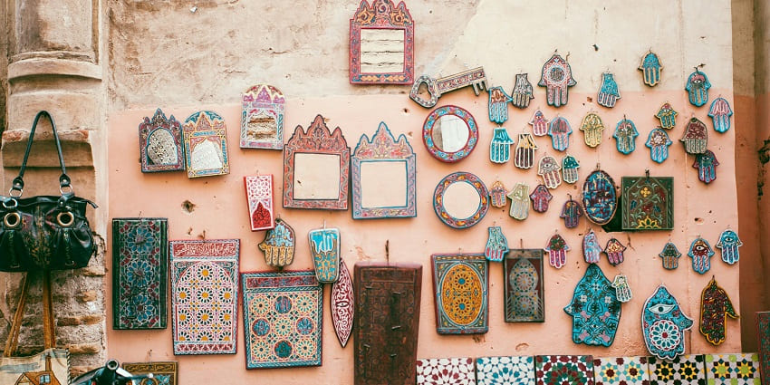Image of a market with mirrors on the wall decorated with colourful things