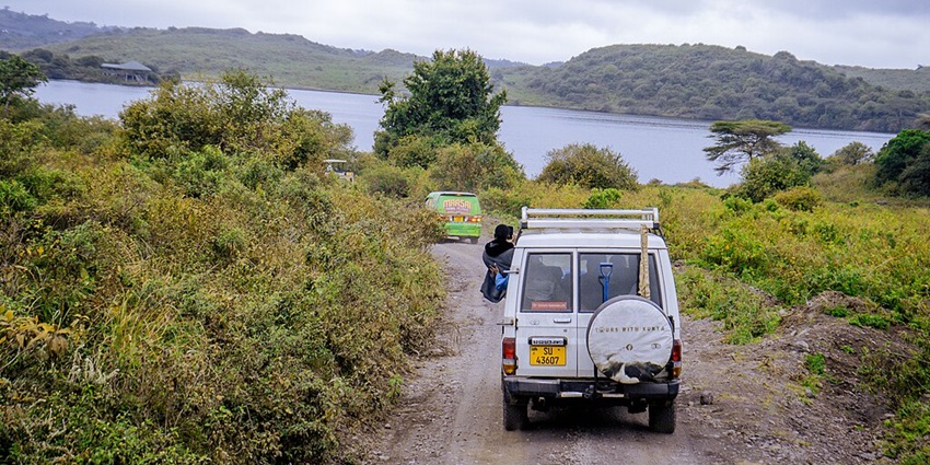Multiple tourist cars with a person looking out of the window at Arusha
National Park.