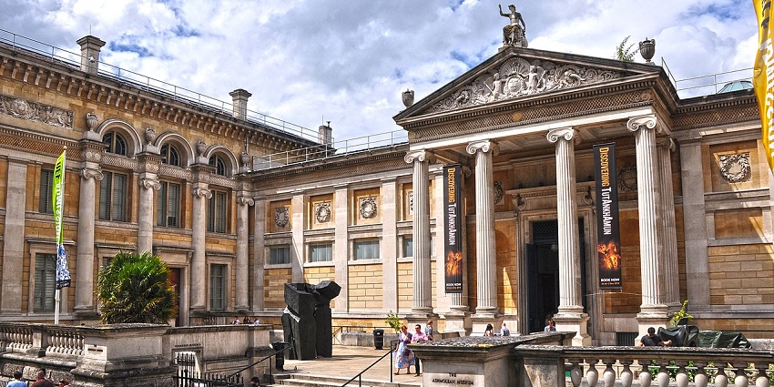 An image showing the grand entrance bustling with people of the Ashmolean Museum, Oxford.