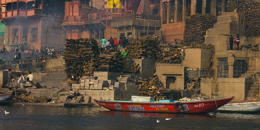 Image of boat near Buildings in Town near the ghat and people standing