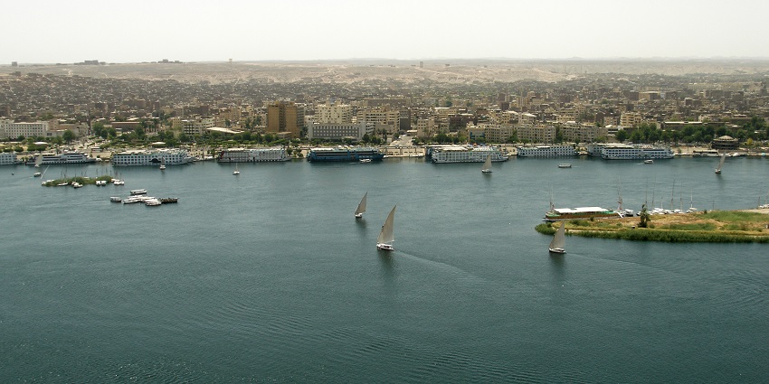 A panoramic view of Aswan city featuring tall buildings situated on the bank of Nile.