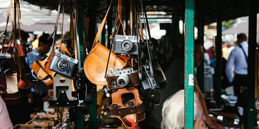 Image of a Flea market with hanging bags and camera looking design bags for sale
