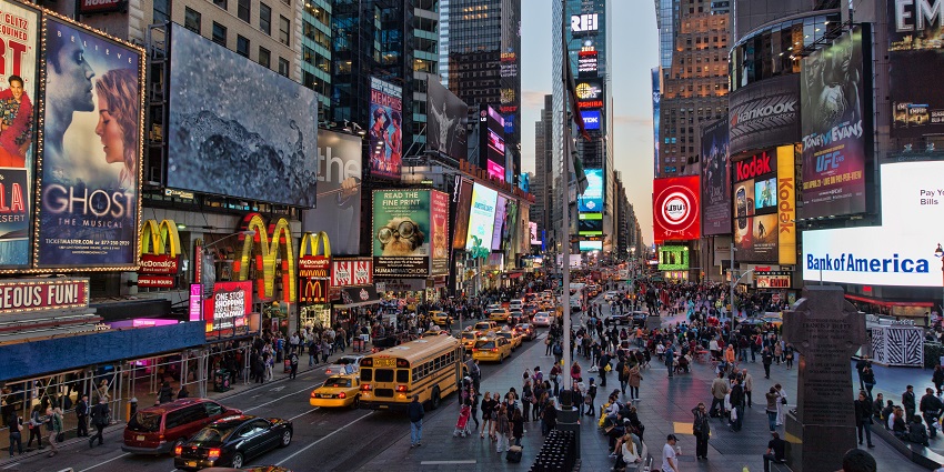 An image of Vibrant Times Square at night with glowing billboards, busy streets, and bustling crowds.