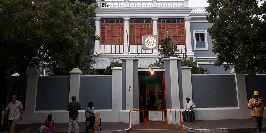 An image of Aurobindo Ashram, with its peaceful surroundings and visitors meditating.
