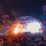 Image of people on concert dancing in front of stage in a music festival event