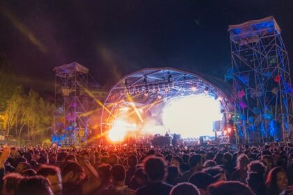 Image of people on concert dancing in front of stage in a music festival event