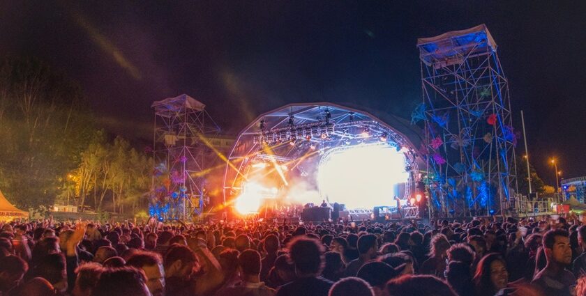 Image of people on concert dancing in front of stage in a music festival event