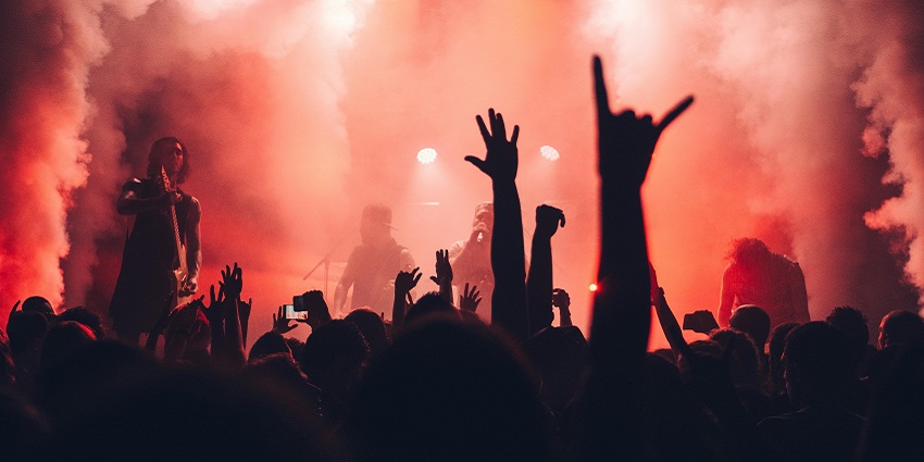 Image of a lively audience enjoying a vibrant band performance in an energetic atmosphere.