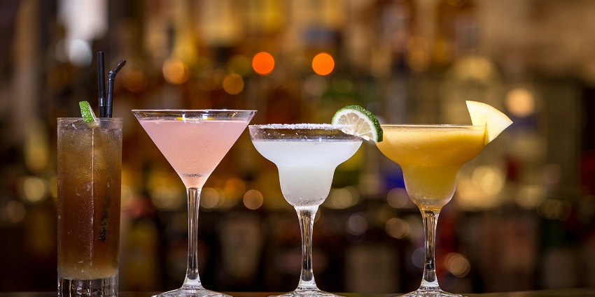 An image showing drinks and modern business bar interior featuring elegant decor.