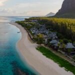 A pristine beach with white sand alongside whose shore there are several boats present.