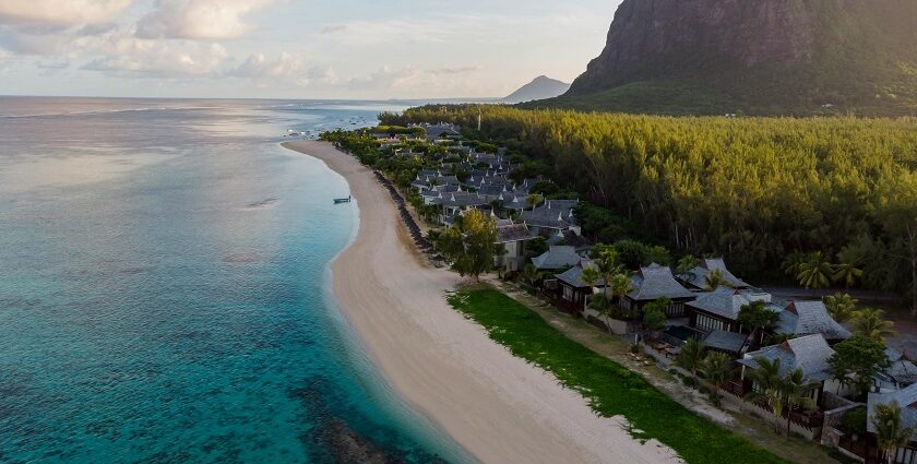 A pristine beach with white sand alongside whose shore there are several boats present.