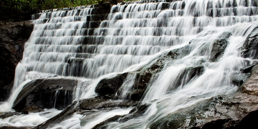 Serene waterfall surrounded by lush greenery and scenic landscapes, featured in Pachmarhi travel guide.